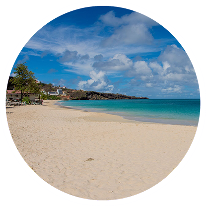 A beach in a circle with a blue sky and white sand, perfect for snorkeling in Grenada.