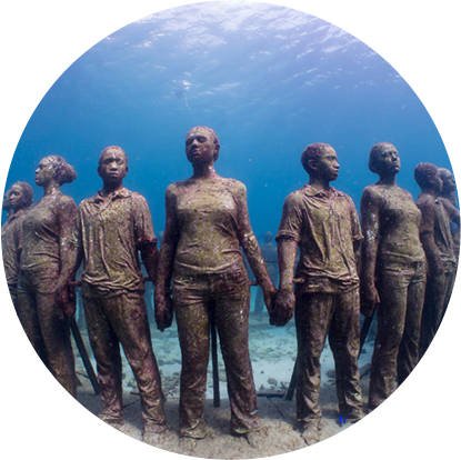 A group of statues under water in the Grenada Underwater Sculpture Park.