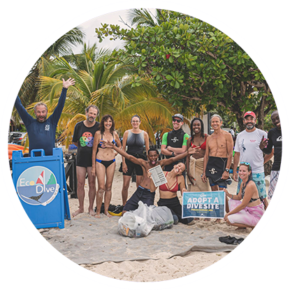 A group of scuba divers posing for a photo on the beach in Grenada.