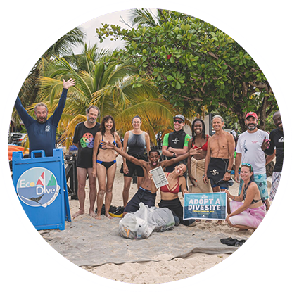 A group of scuba divers posing for a photo on the beach in Grenada.