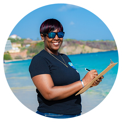 A woman holding a clipboard on the beach near Grenada's underwater sculpture park.