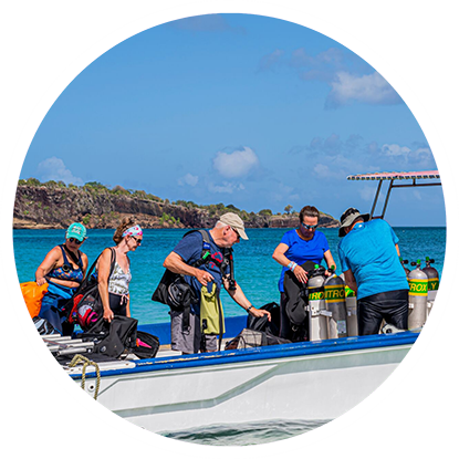 A group of people on a boat scuba diving in Grenada.