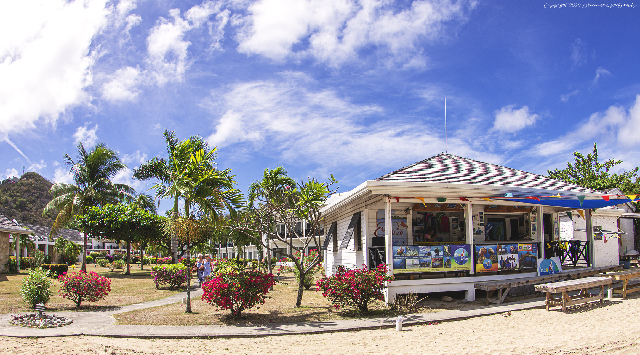 A small building on a beach with palm trees in the background, perfect for those looking to scuba dive in Grenada.