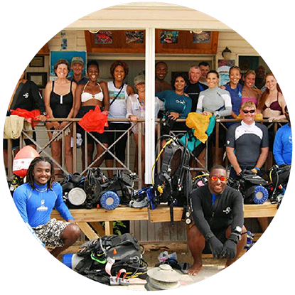 A group of people posing for a picture with their scuba gear at the Grenada Underwater Sculpture Park.