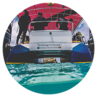 A group of people on a boat in the water, heading towards Grenada's Underwater Sculpture Park.